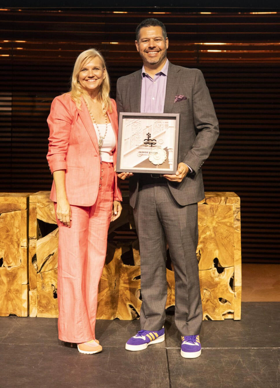 Jill Vaughan, president and CEO of the Downtown Orlando Partnership, stands with Jarrod Dillon, holding the award for 2024 Downtowner of the Year. (FROM WITHIN ART/COURTESY OF DOWNTOWN ORLANDO PARTNERSHIP)